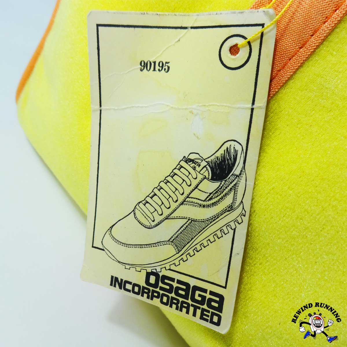 Yellow shoe with Osaga Incorporated label on a white background
