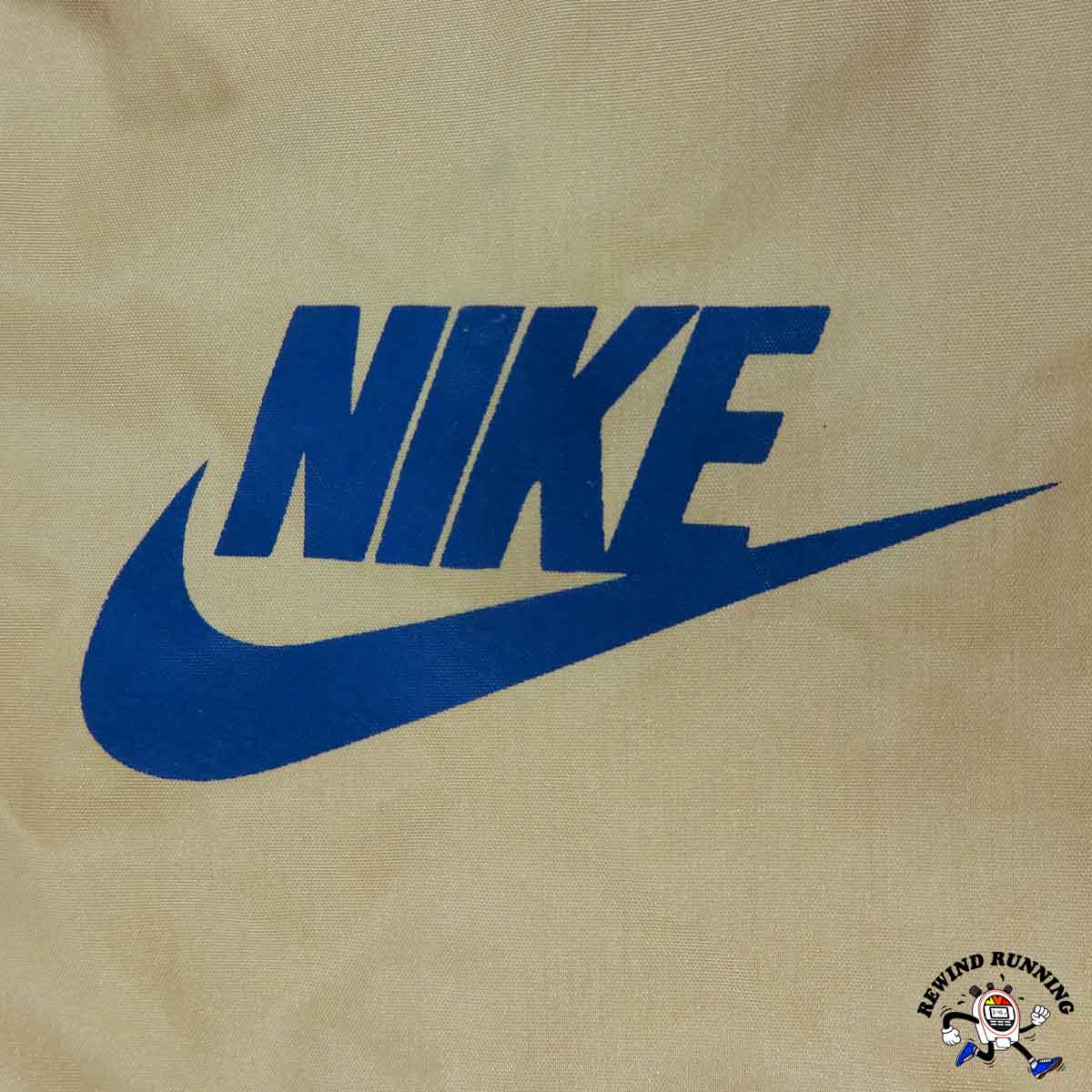 Blue Nike logo on a beige background