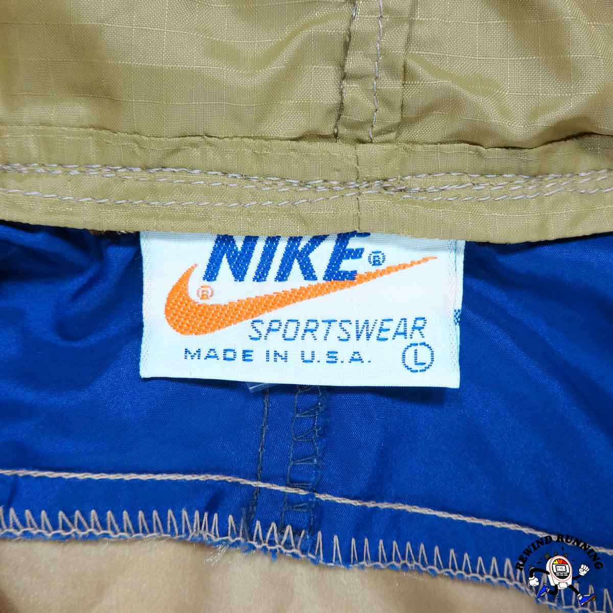 Close-up of a Nike Sportswear label on a garment with blue and beige colors.