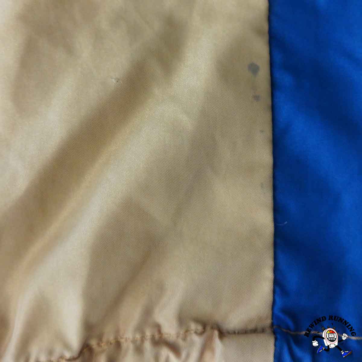 Close-up of beige fabric with a blue section, possibly from a garment or material sample.