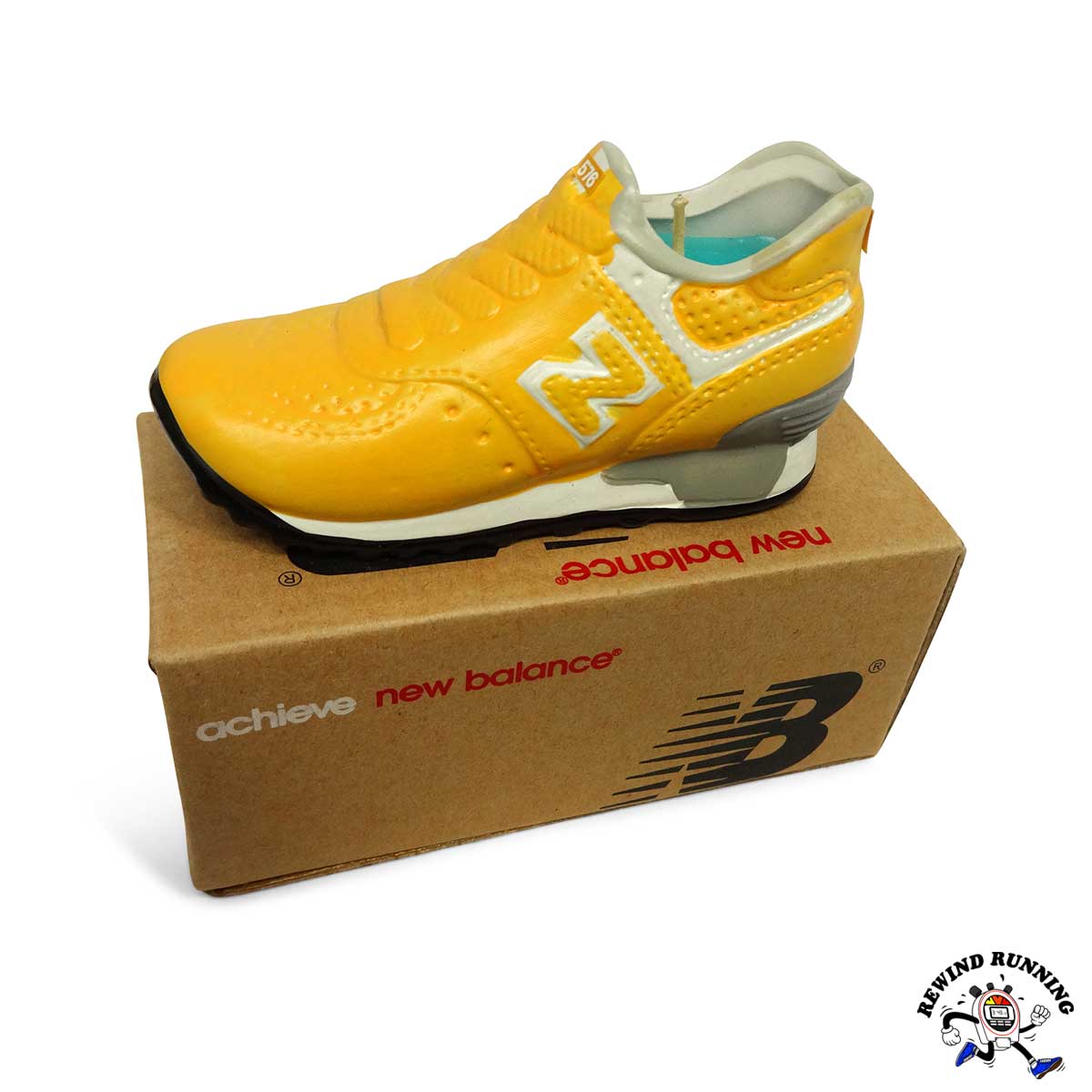 Yellow New Balance 576 sneaker on a cardboard box with 'New Balance' branding.