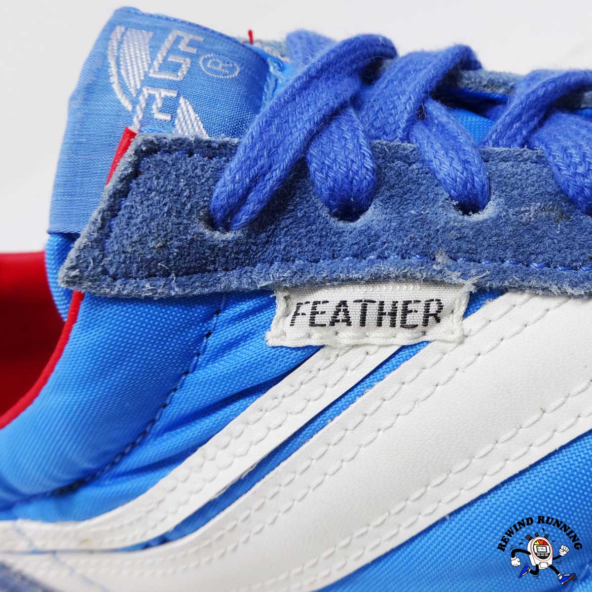 Close-up of a blue and white sneaker with 'Feather' branding on a white background